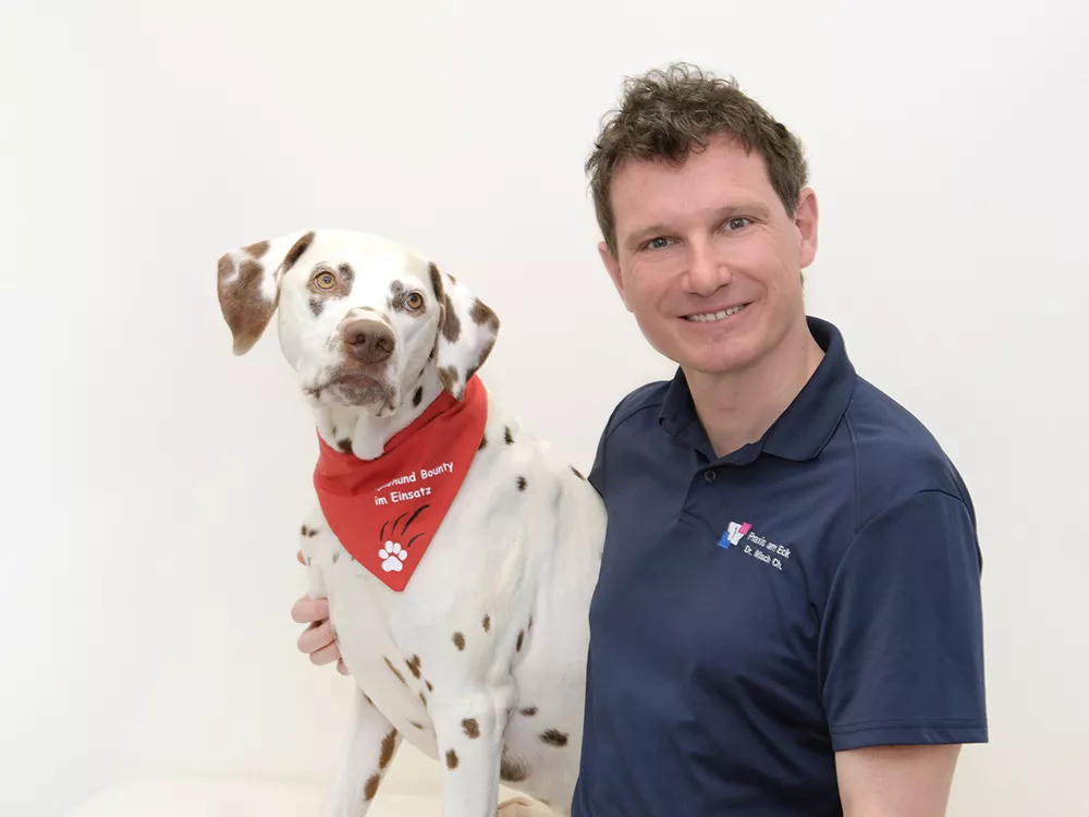 Bild zeigt Dr. Christoph Misch mit Therapiehund Bounty